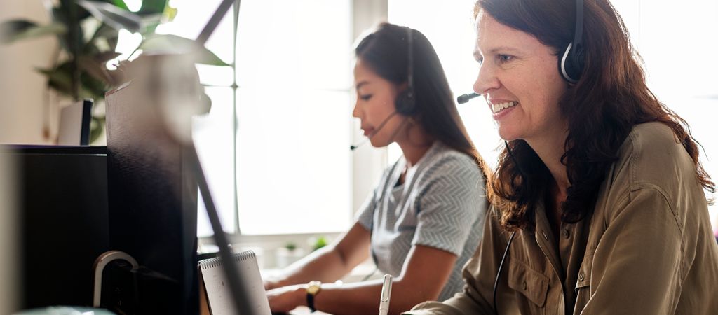 A call center employee happily helps a guest book a stay in the Smokies.