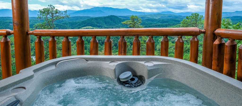 A bubbling hot tub overlooks Great Smoky Mountain vistas at a modern log cabin.